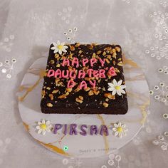 a birthday cake that says happy daughter's day with flowers and nuts on it