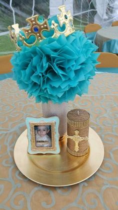 a table with a gold plate and a blue centerpiece on it, surrounded by other decorations