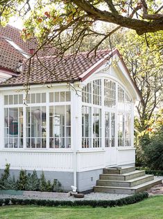 a white house sitting on top of a lush green field