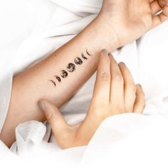 a woman's arm with the phases of her life tattooed on it, in black ink