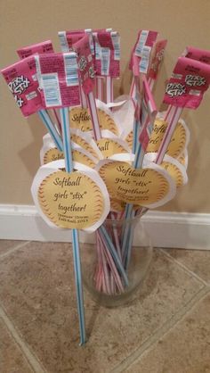 a vase filled with baseball themed candy sticks