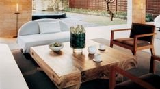 a living room filled with furniture next to a wooden table and wall mounted planter