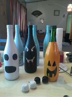 several bottles with faces painted on them sitting on a table