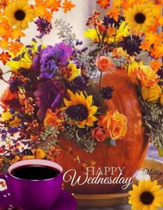 a cup of coffee sitting next to a vase with sunflowers and flowers on it