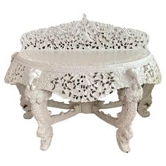 an ornately decorated white table with carvings on it