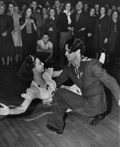 an old black and white photo of a man dancing with a woman on the dance floor