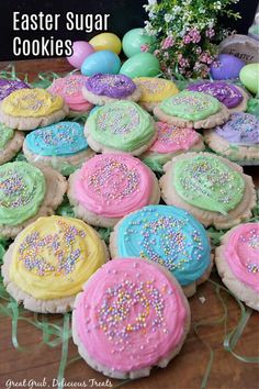 there are many decorated cookies on the table and one is pink, green, blue, yellow