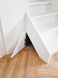 an open white shelf on top of a wooden floor