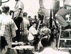 black and white photograph of people sitting at tables in front of an old camera man