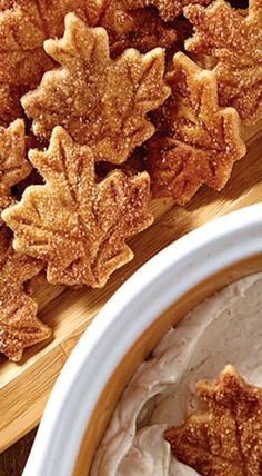 some food is in a bowl on a cutting board and next to it are leaves