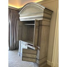 an armoire with drawers in a room