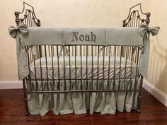 a baby crib with the name noah on it's side and bowknots at the bottom