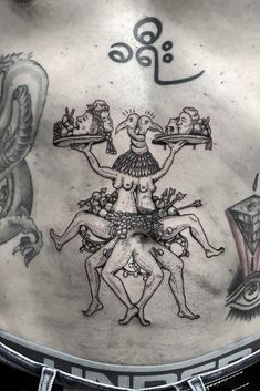 the back of a man's stomach with tattoos on it and an image of two men holding trays