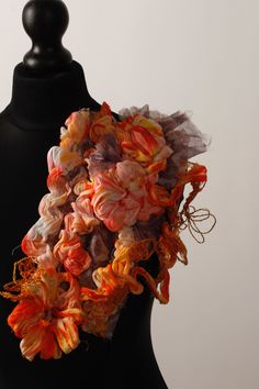 an orange and pink scarf is on a mannequin's headdress