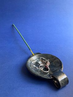 a metal object with a wire attached to it on a blue surface, showing the end of the handle