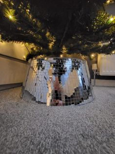 the reflection of a person in a mirror ball on the ground next to a tree