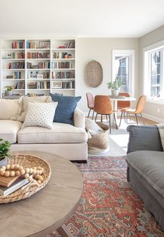 a living room filled with lots of furniture and bookshelves full of books on shelves