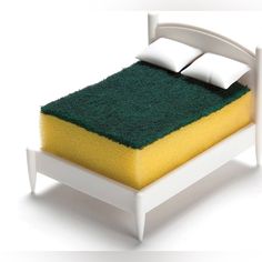 a bed with a green and yellow sponge on the top of it's headboard