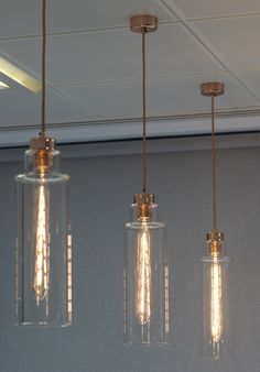 Copper pendulum lights with a cylindrical, glass light shade. Pendulum Lights, Office Transformation, Floor To Ceiling Windows, Elegant Lighting, Desk Lamps, Digital Transformation, Concrete Floors, Working Area