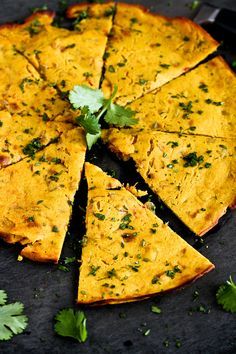 a close up of a pizza on a plate with cilantro and parsley