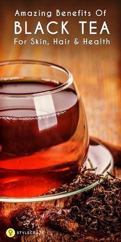 a cup of black tea on top of a wooden table