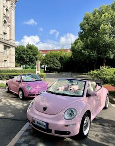 two pink cars parked in front of a building