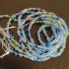 Waist Beads Can Be Used For Fashion, Spiritual And/Or Weight Management. Beads Vary In Different Shades And Sizes. The Waist Bead Is 50 Cm Long With 46 Cm Of Beads Color: Blue W/ Purple & Green Size: 6/0 Beads Fit: Tie On Materials: Cotton & Czech Beads *Some Colors May Fade Over Time After Being Exposed To Water.* Purple Dangle Earrings, Silver Bridesmaid, Cat Enamel Pin, Hand Painted Roses, Silver Bar Necklace, Crystal Choker Necklace, Waist Beads, Heart Drop Earrings, Crystal Choker