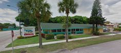 this is an image of a motel on the corner of a street with palm trees