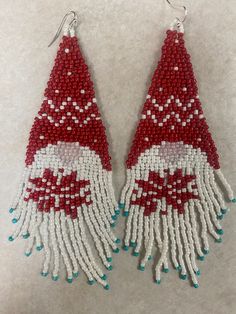 red and white beaded earrings with santa clause on it, hanging from silver hooks