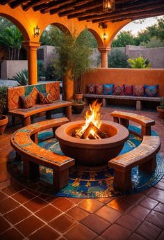 an outdoor fire pit surrounded by benches and potted plants in a courtyard with tiled flooring