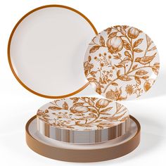 two plates sitting on top of each other with gold trimmings and floral designs