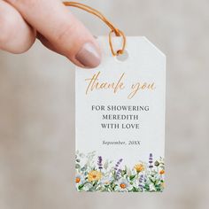 a hand holding a thank you tag with flowers on it and the words, for showing meridith with love