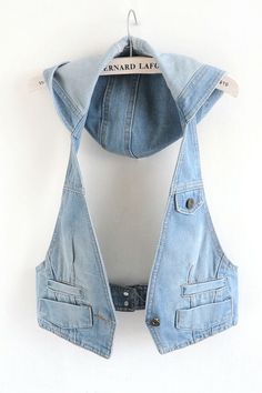 a denim vest hanging on a white wall