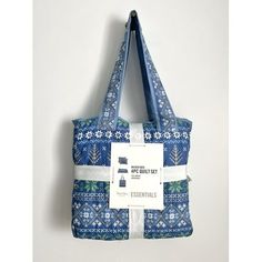 a blue and white tote bag hanging on the wall with an advertise tag