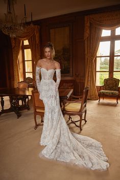 a woman in a white wedding dress posing for the camera with her hands on her hips