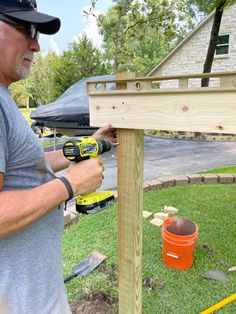 a man working on a wooden post in the yard