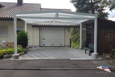 a house with a white pergolan over the driveway