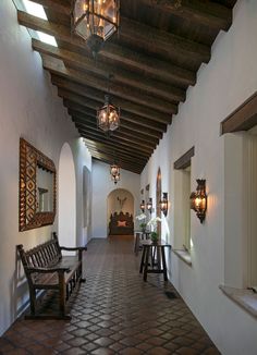 the hallway is lined with wooden benches and lanterns hanging from the ceiling, along with decorative wall sconces