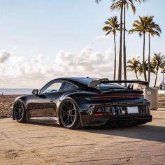 a black sports car parked on the beach