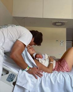 a man and woman holding a baby in a hospital bed