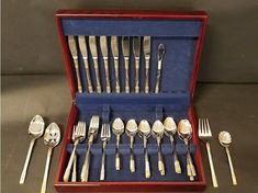 an assortment of silverware in a wooden box