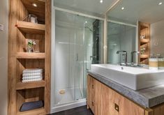 a bathroom with a sink, shower and shelves