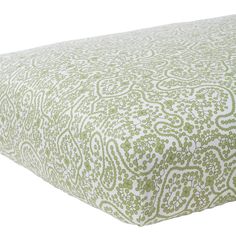 a green and white bed spread with an intricate pattern