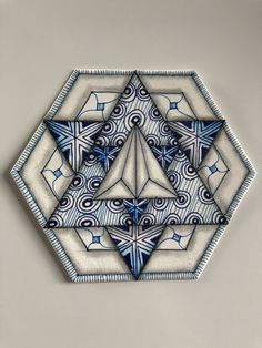 a blue and white tile design on the wall in front of a gray background,