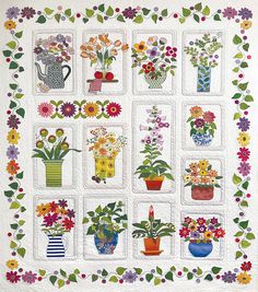 a quilted wall hanging with potted plants and flowers on it's sides