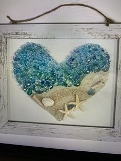 a heart made out of sea glass and sand