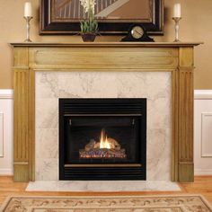 a fire place in a living room with a painting on the wall and candles around it