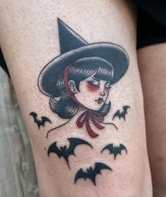 a woman wearing a witches hat with bats on her thigh