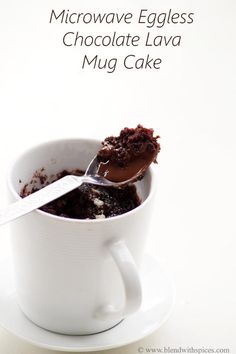 microwave eggless chocolate lava mug cake in a white cup on a saucer with spoon