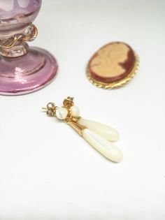 "Delicate UNUSED vintage Edwardian style long stud earrings, made in the 80s with natural mother of pearl. They have an elegant shape, material and color: the natural ivory color of the nacre, pearly, with a round bead from where the tear drops and old gold tone brass embellishments and closure. I bring them from an old wharehouse. They will get to you on a cardboard on the original paper bag from the shop where it was meant to be sold before it closed. These will be lovely for brides and any ro Elegant Cream Teardrop Jewelry, Vintage Teardrop Earrings For Formal Occasion, Vintage White Pearl Earrings, Vintage White Dangle Pearl Earrings, Antique White Drop Earrings, Vintage White Pearl Drop Earrings, Vintage Teardrop Pearl Earrings For Pierced Ears, Vintage Handmade White Pearl Earrings, Victorian White Pearl Earrings For Gift